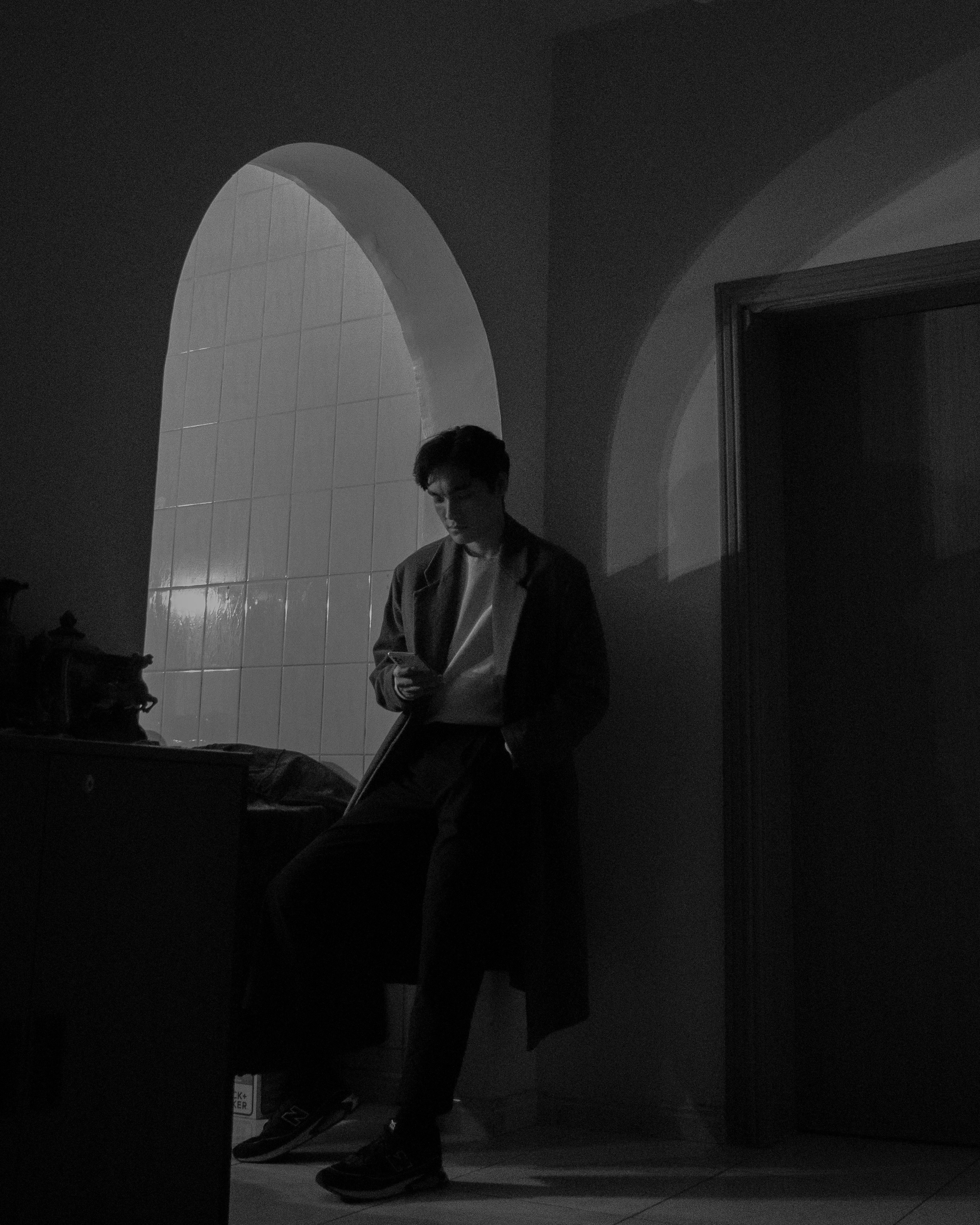 a man sitting in a bath room next to a toilet