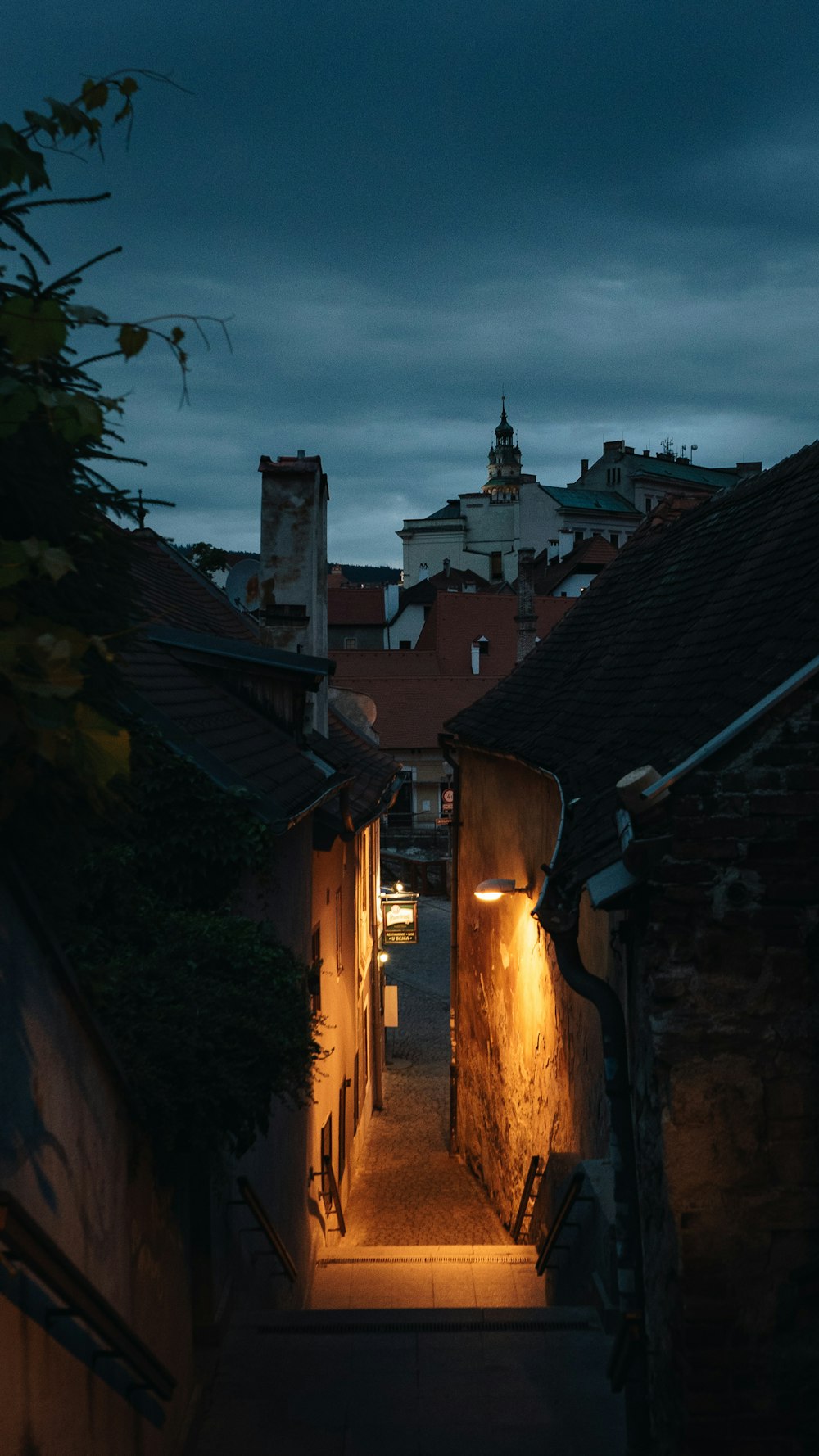 a dark alley way with a clock tower in the distance