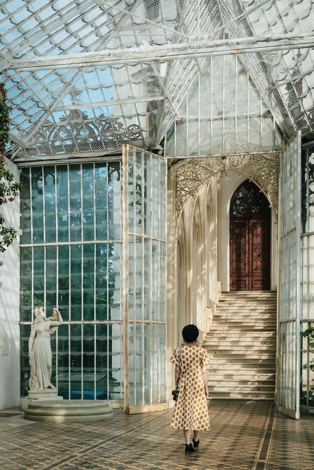 a woman in a white and yellow dress standing in front of a building