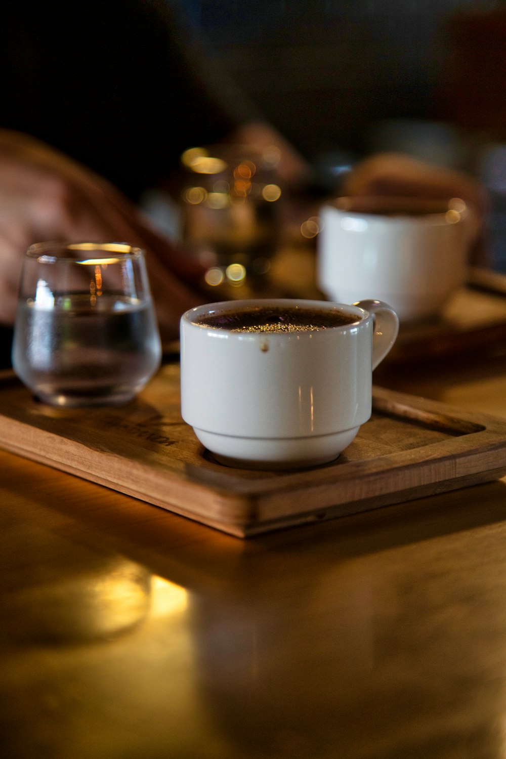 a cup of coffee sitting on top of a wooden tray