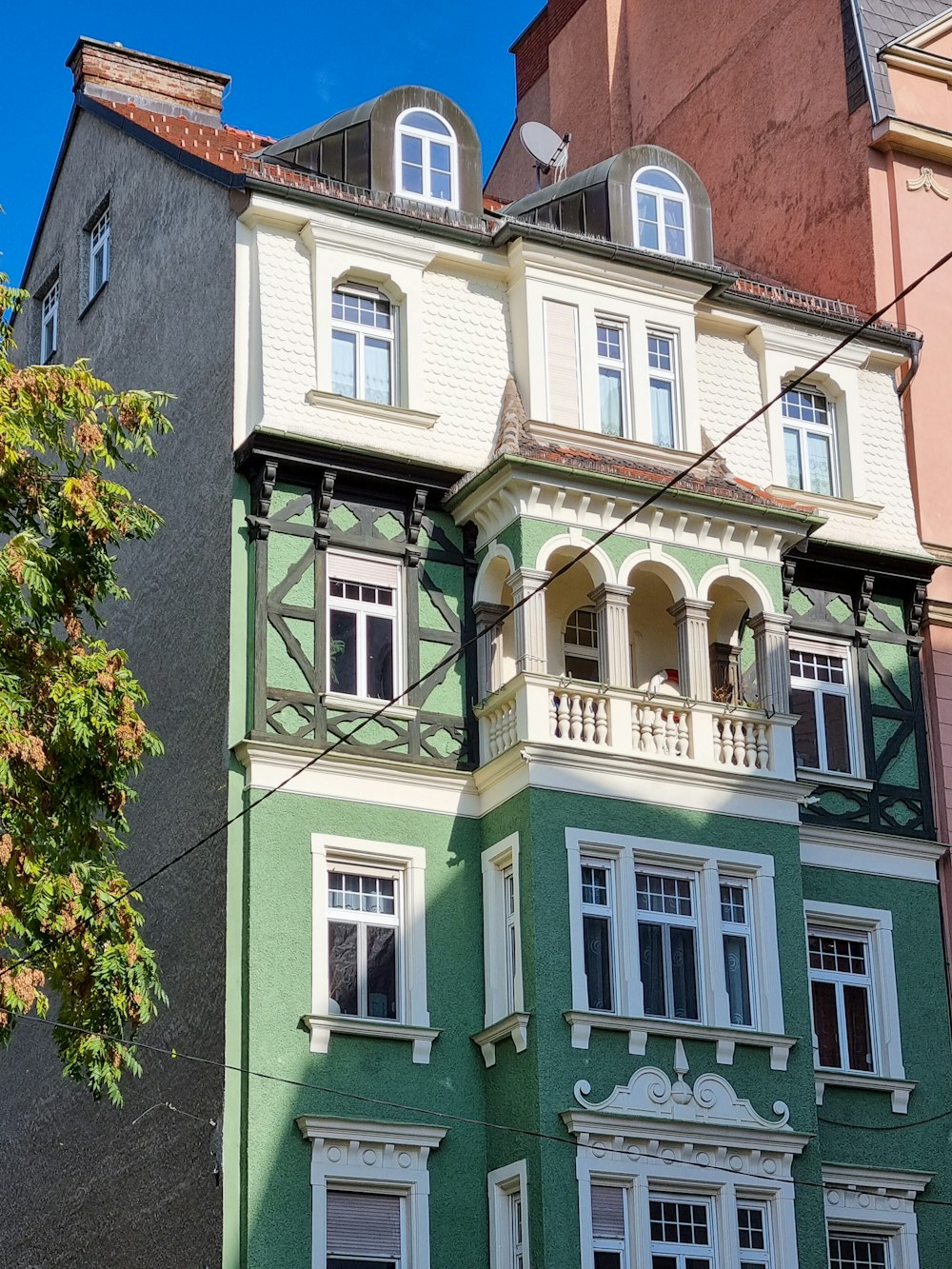 a green and white building with a clock on the front of it