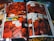 A comic book is open to a colorful, action-packed spread. The pages are filled with detailed illustrations and dialogue bubbles, prominently featuring characters in dramatic scenes and dynamic poses. The artwork is vibrant, with a focus on red and orange hues that create an intense atmosphere.