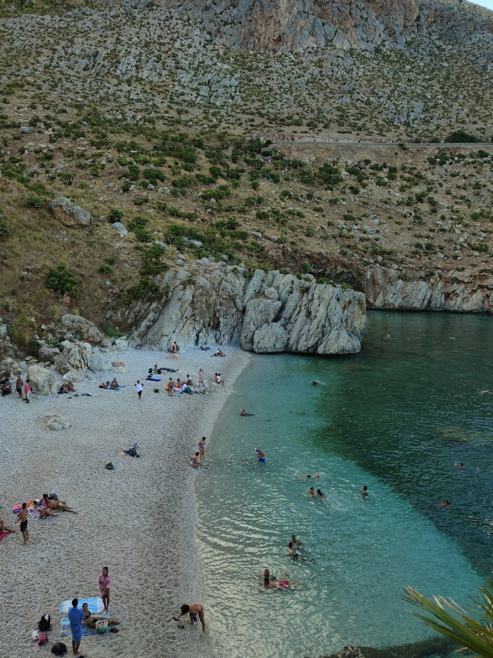 a group of people sitting on top of a sandy beach