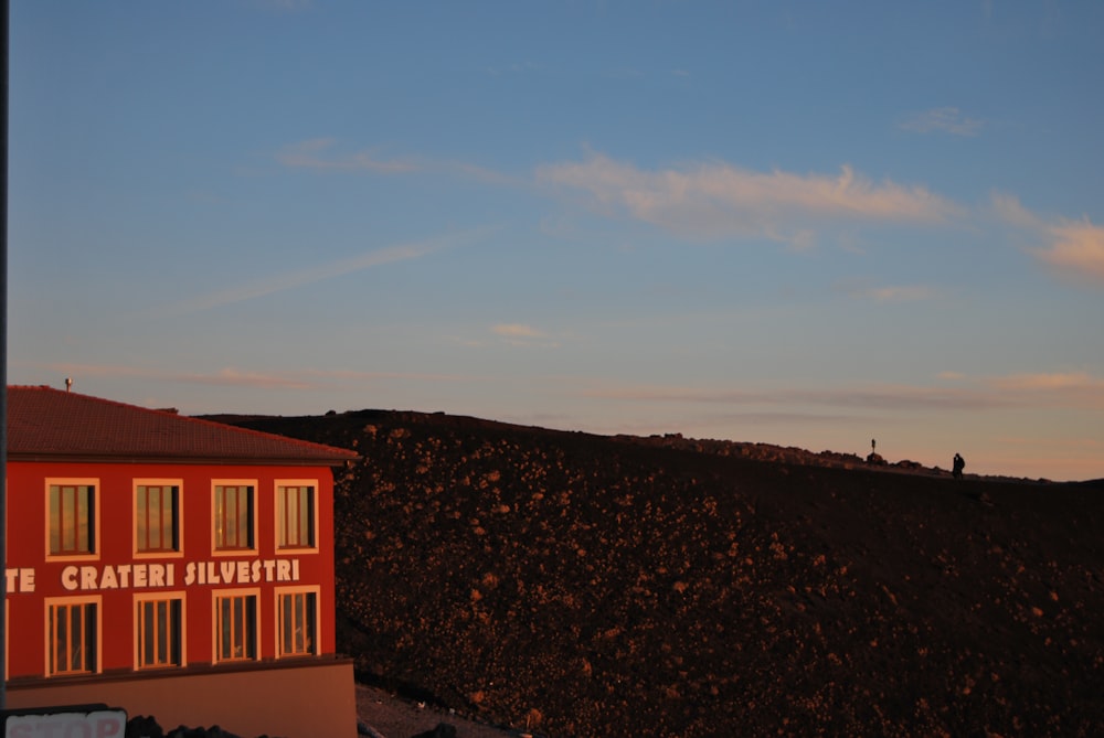 a red building sitting on the side of a hill