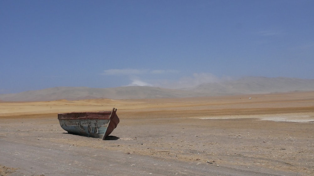 a boat sitting in the middle of a desert
