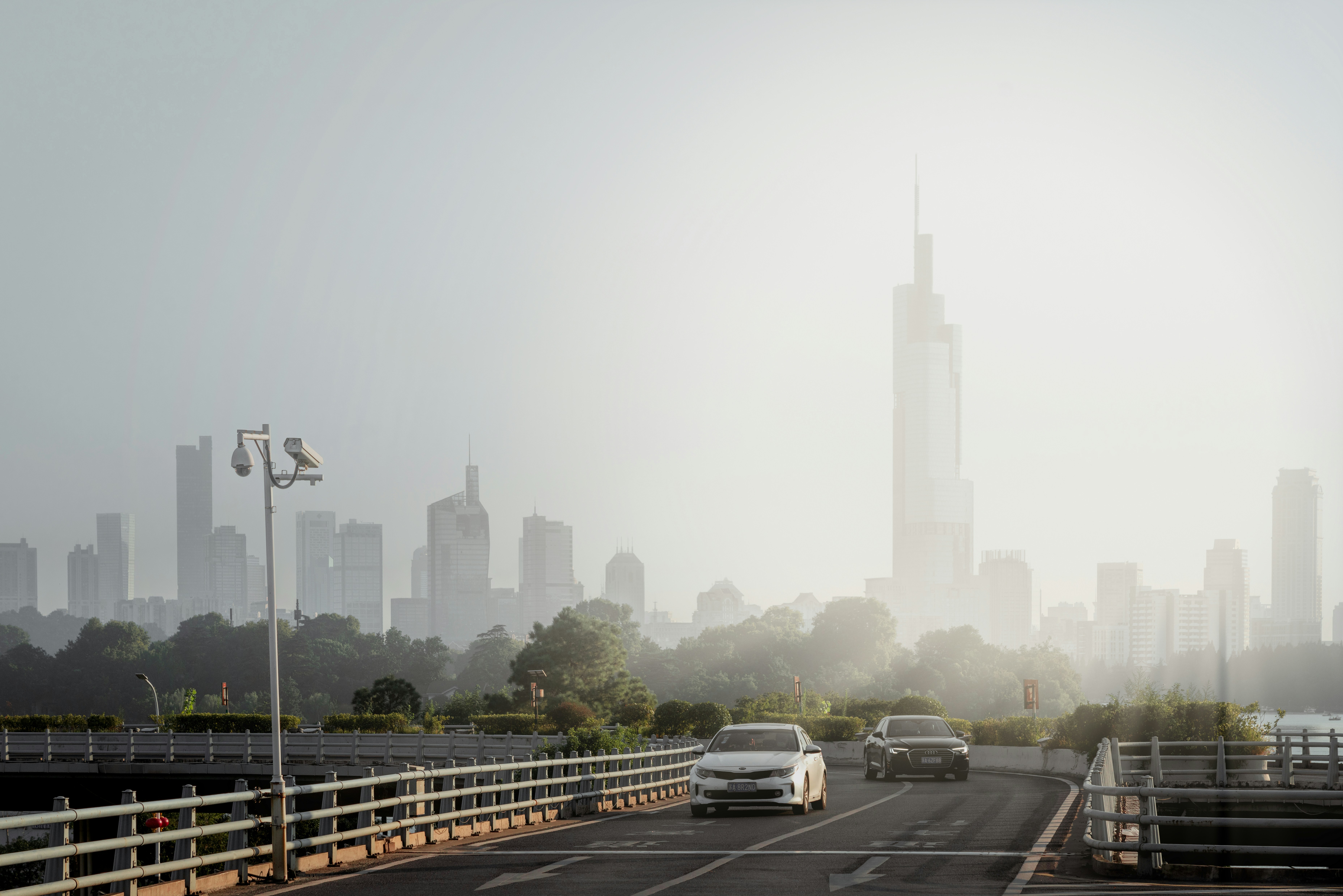 cars driving on a highway with a city skyline in the background