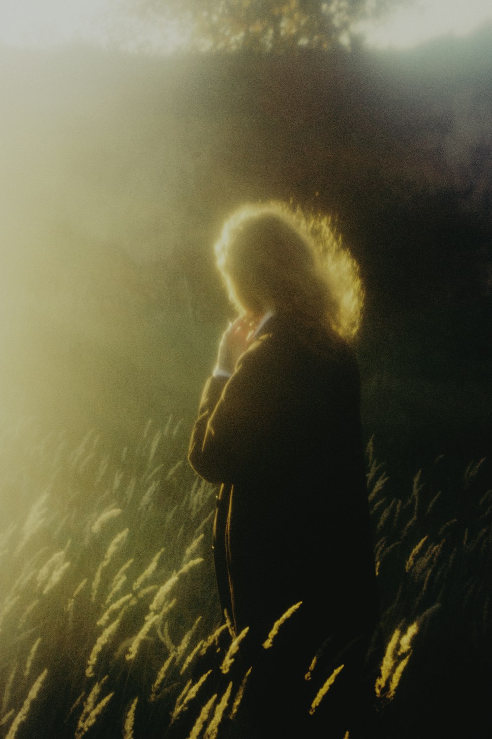 a woman standing in a field of tall grass