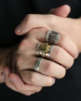 A hand wearing multiple rings, showcasing different designs.