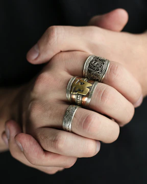 Stacked rings in mixed metals shown on a youthful hand with modern street style nails.