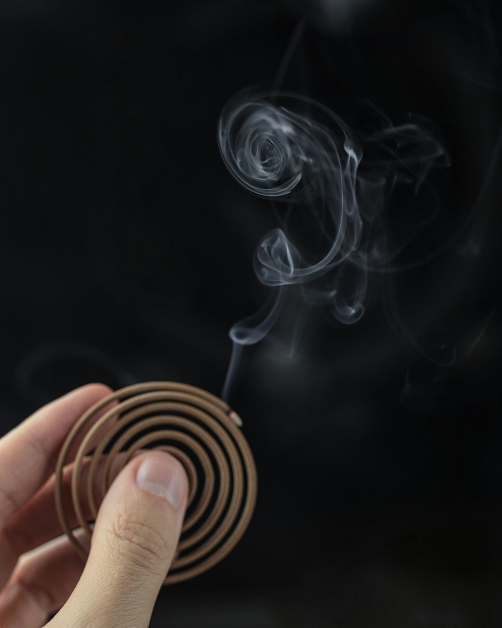 a hand holding a match stick with smoke coming out of it