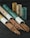 A collection of incense sticks partially pulled out of cylindrical cardboard containers, with more containers standing upright in the background on a dark wooden surface.