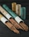 A collection of incense sticks partially pulled out of cylindrical cardboard containers, with more containers standing upright in the background on a dark wooden surface.