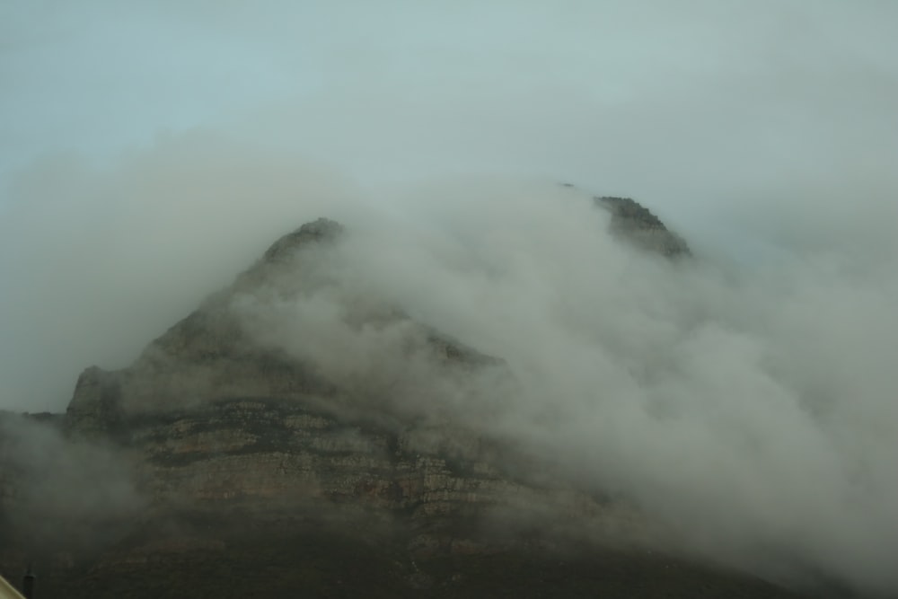 a mountain covered in clouds with a sky background