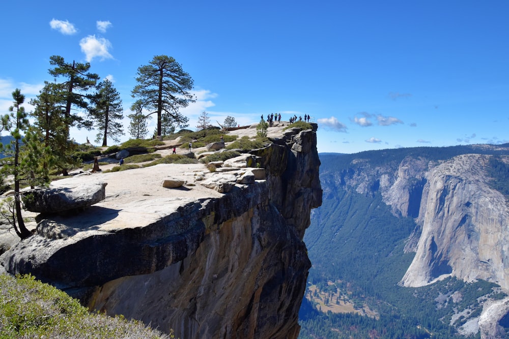 a man standing on top of a cliff overlooking a valley