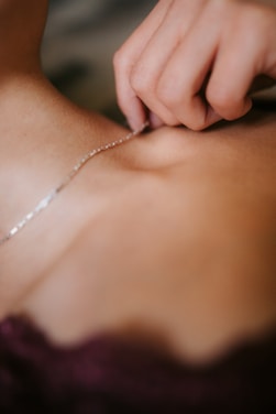 Close-up of a delicate silver necklace sparkling softly under warm light.