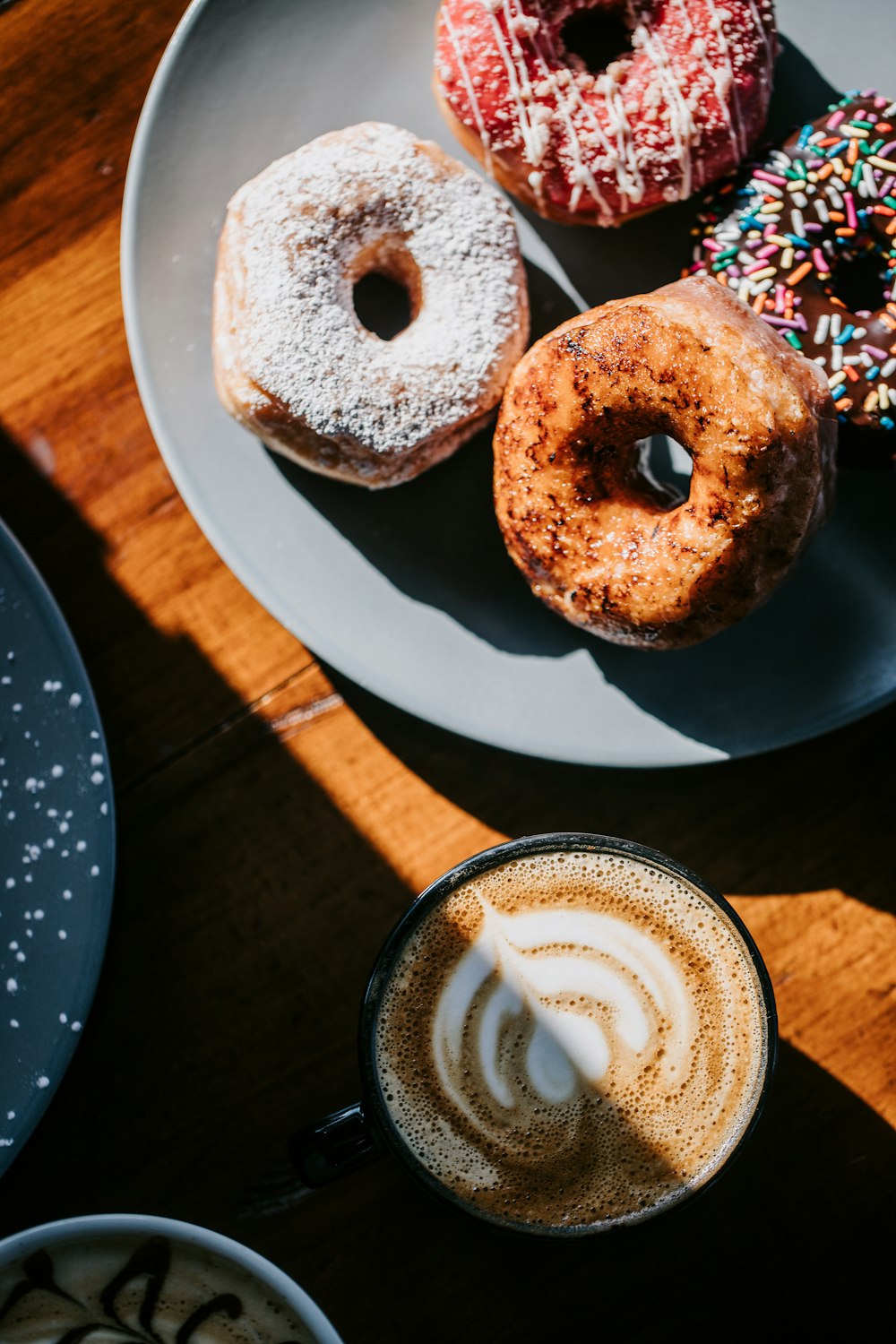 a plate of doughnuts and a cup of coffee
