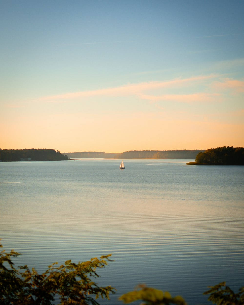 a sailboat on a lake at sunset