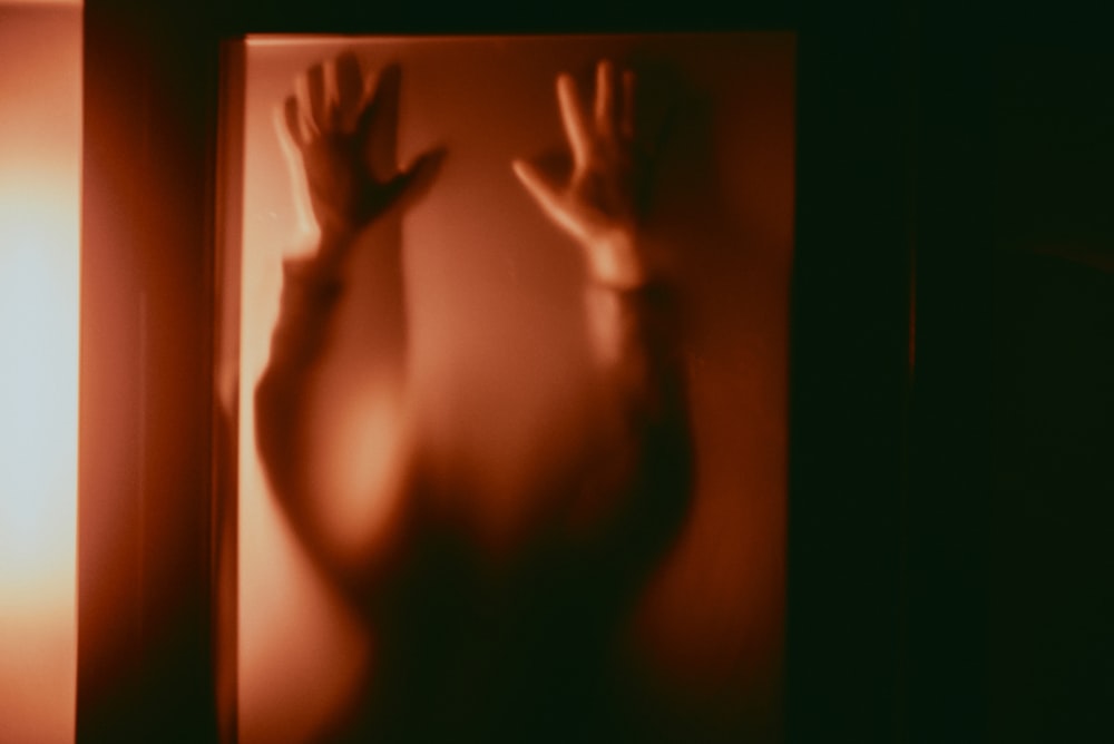 a blurry photo of a person's hand casting a shadow on a wall