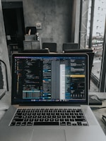 Close-up of a developer coding on a laptop in a modern workspace.