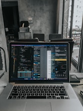 Close-up of hands coding AI algorithms on a laptop in a modern workspace.