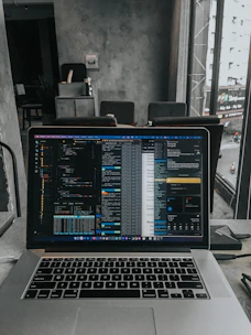 A modern workspace featuring a laptop with AI software on the screen.