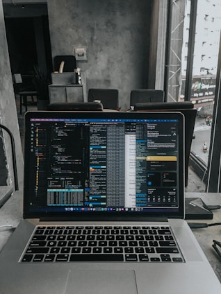 A student working on a laptop coding in a bright, modern workspace