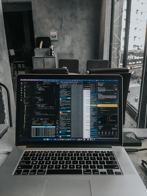 A modern workspace with a laptop displaying code and tech-related graphics