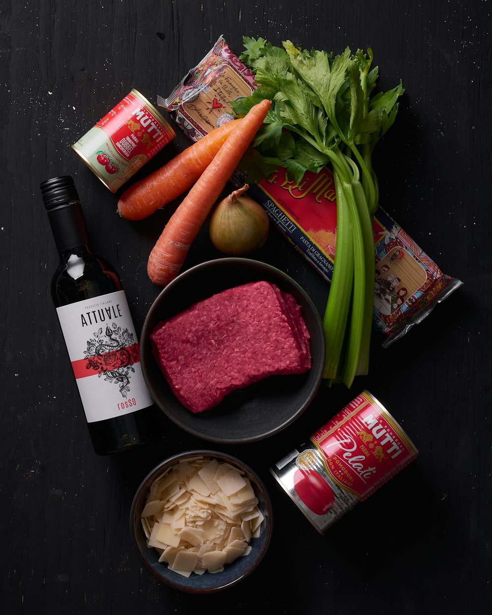 a table topped with a bowl of food and a bottle of wine