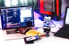 a laptop computer sitting on top of a desk next to a cell phone