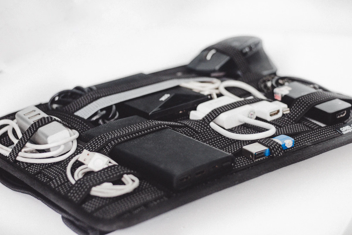 Black cable organizer with elastic loops holding chargers and cords