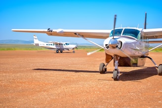 a small airplane sitting on top of a dirt field