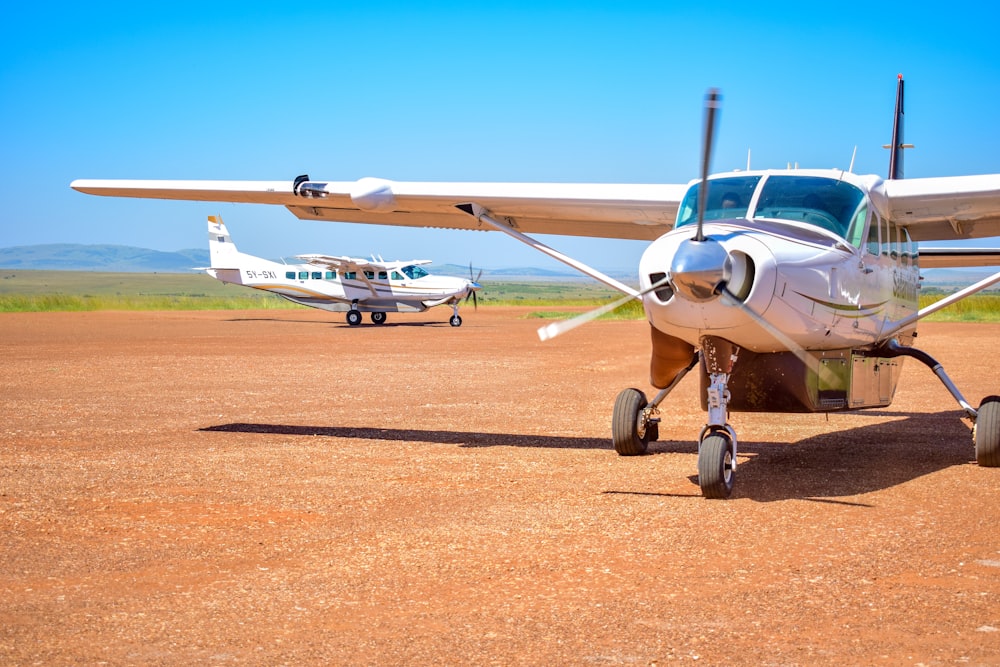 a small airplane sitting on top of a dirt field