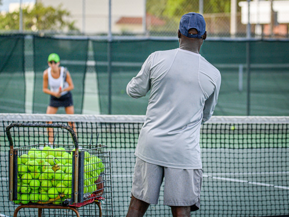 テニスコートでテニスをする男女