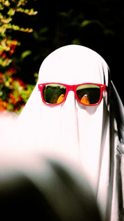 a person wearing a white veil and red sunglasses