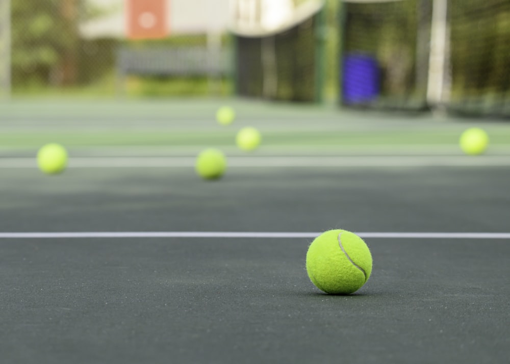 a tennis ball on a tennis court with a net in the background