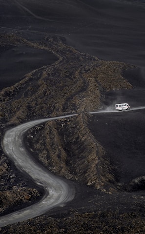 a car driving down a winding road in the mountains