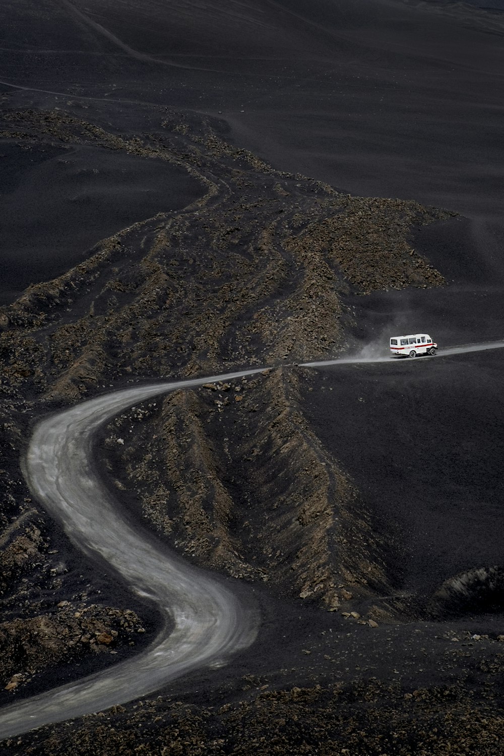 a car driving down a winding road in the mountains