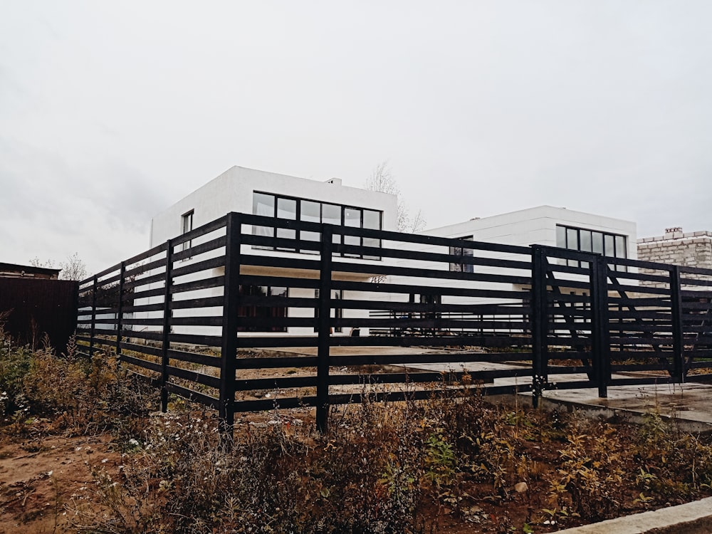 a black and white building sitting on top of a dry grass field