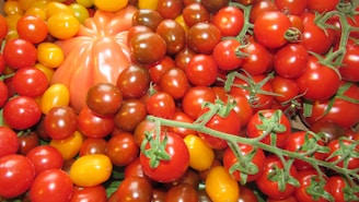 a pile of tomatoes and other fruits and vegetables