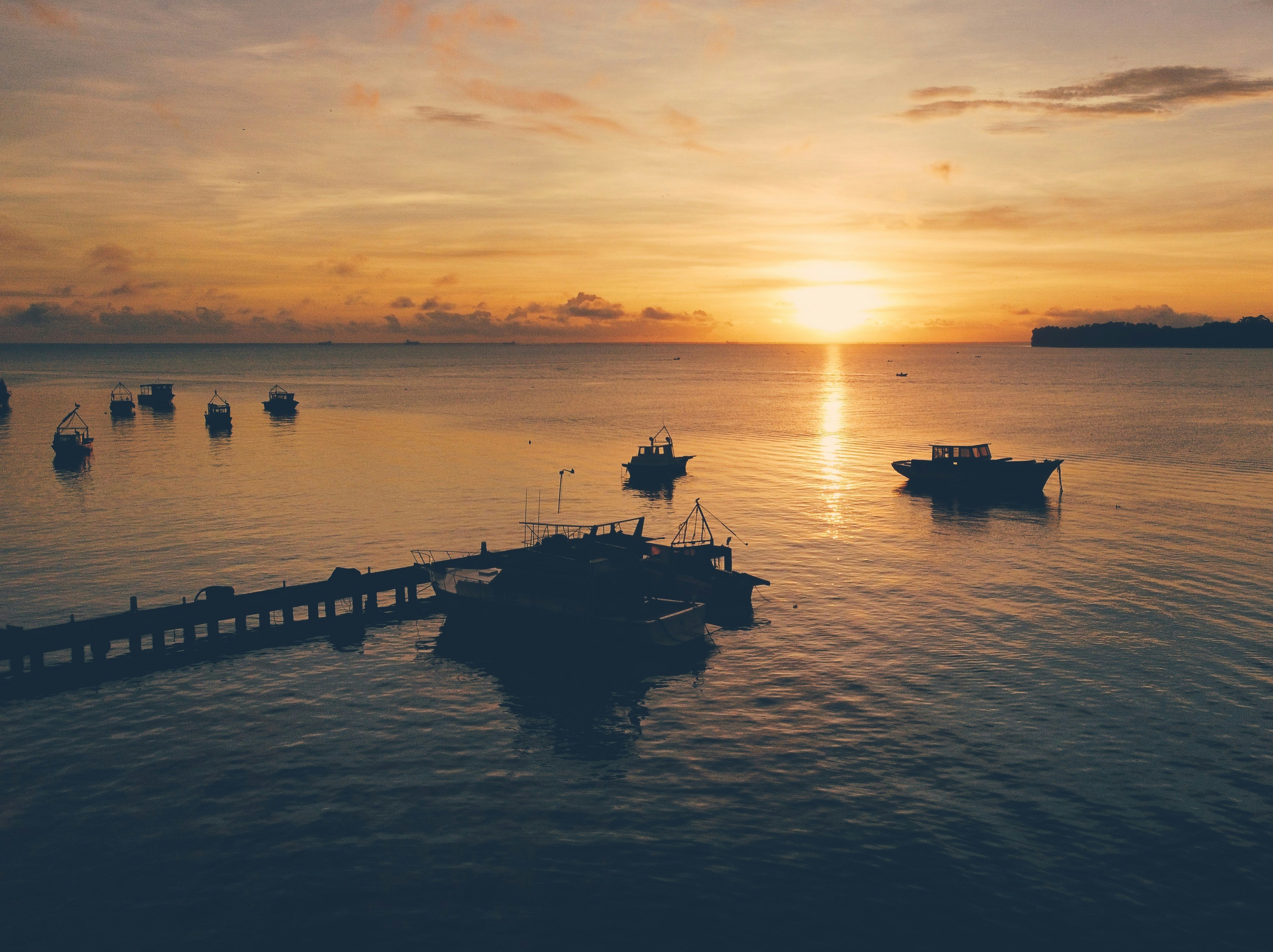 a group of boats floating on top of a body of water, Drone shot of the sunrise in Lívingston, Guatemala. 