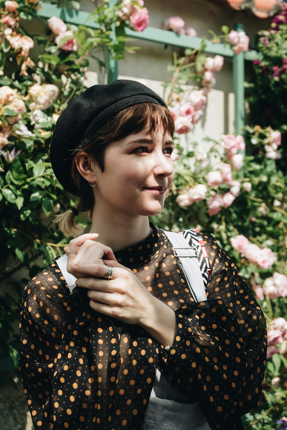 a woman standing in front of a bunch of flowers