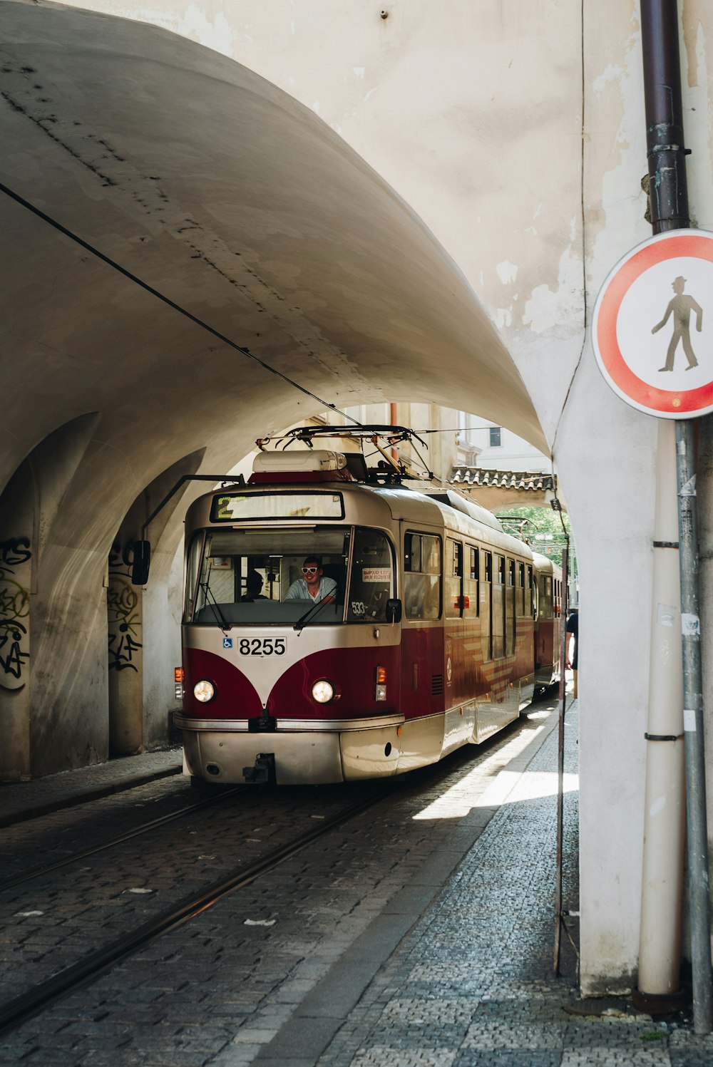 a red and white train traveling through a tunnel