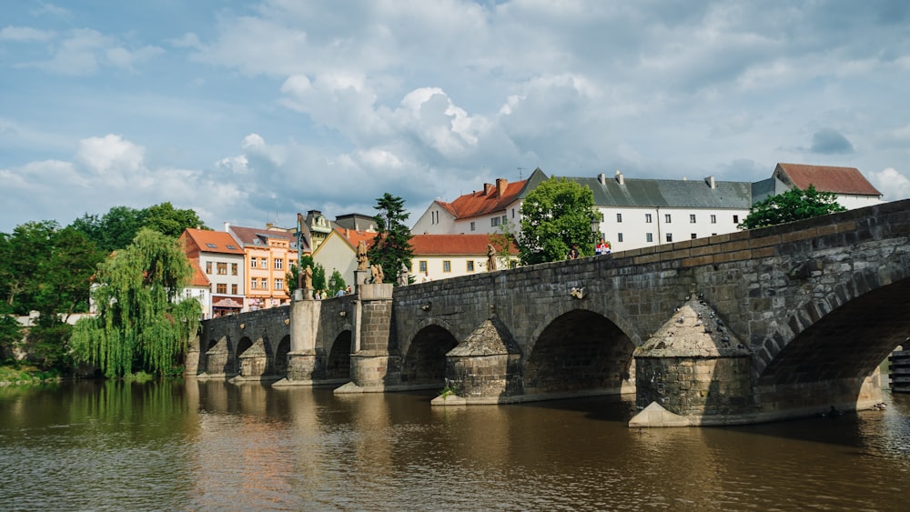 a bridge over a body of water with buildings in the background