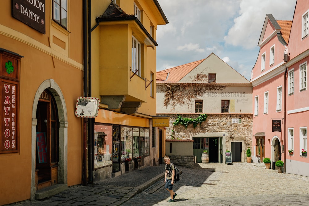 a woman is walking down a cobblestone street