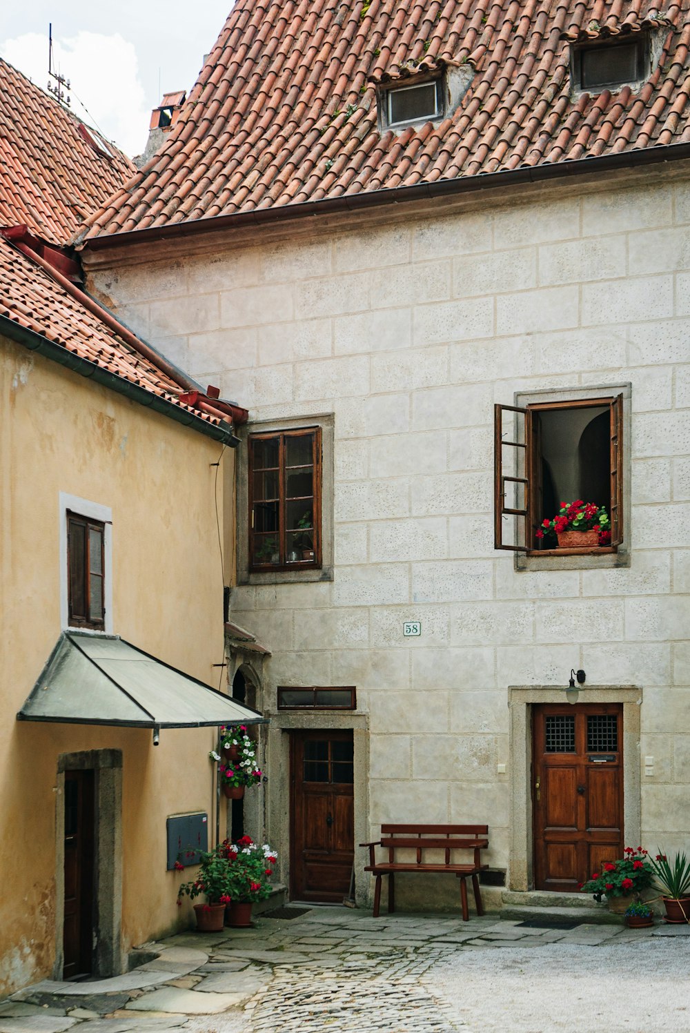 a courtyard with a table and benches in front of a building