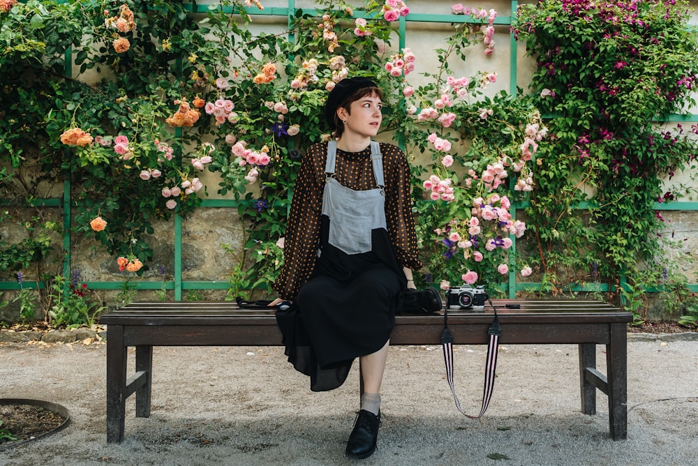 una donna seduta su una panchina di fronte ai fiori