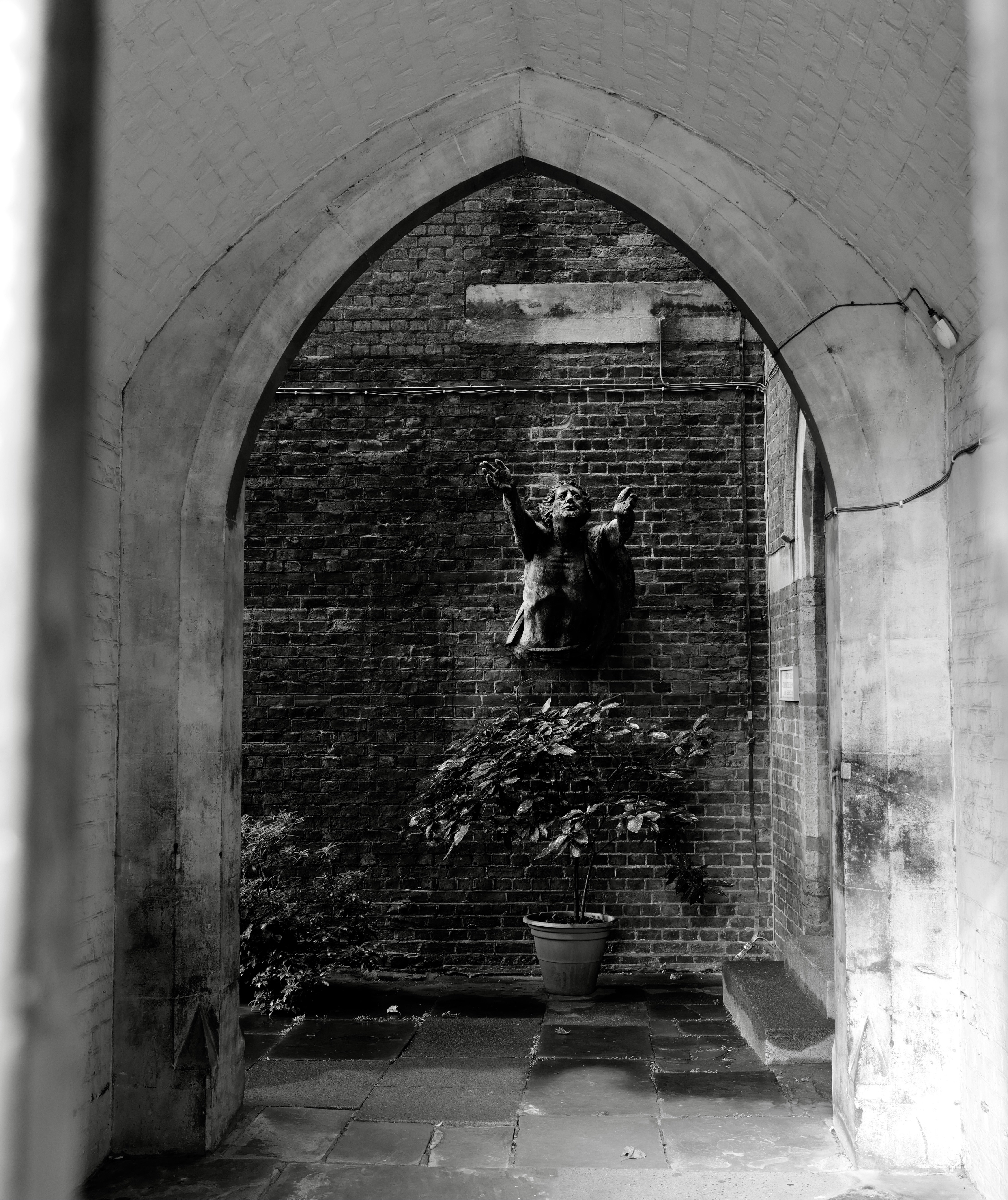 a black and white photo of a brick archway