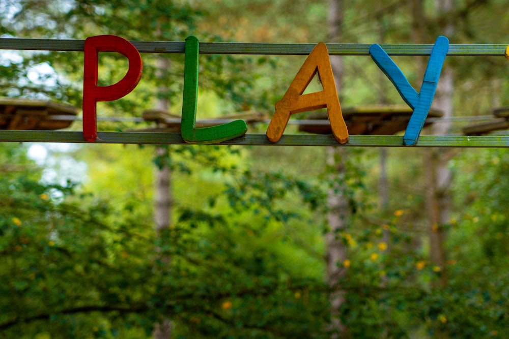 a sign that says play hanging from a rail