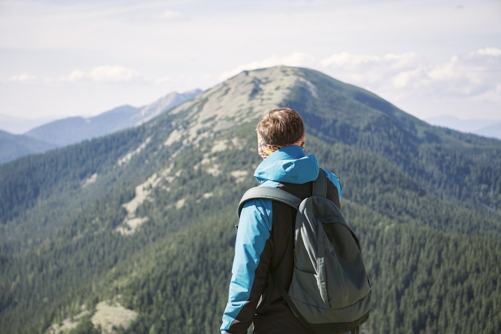 Eine Person mit einem Rucksack schaut auf einen Berg