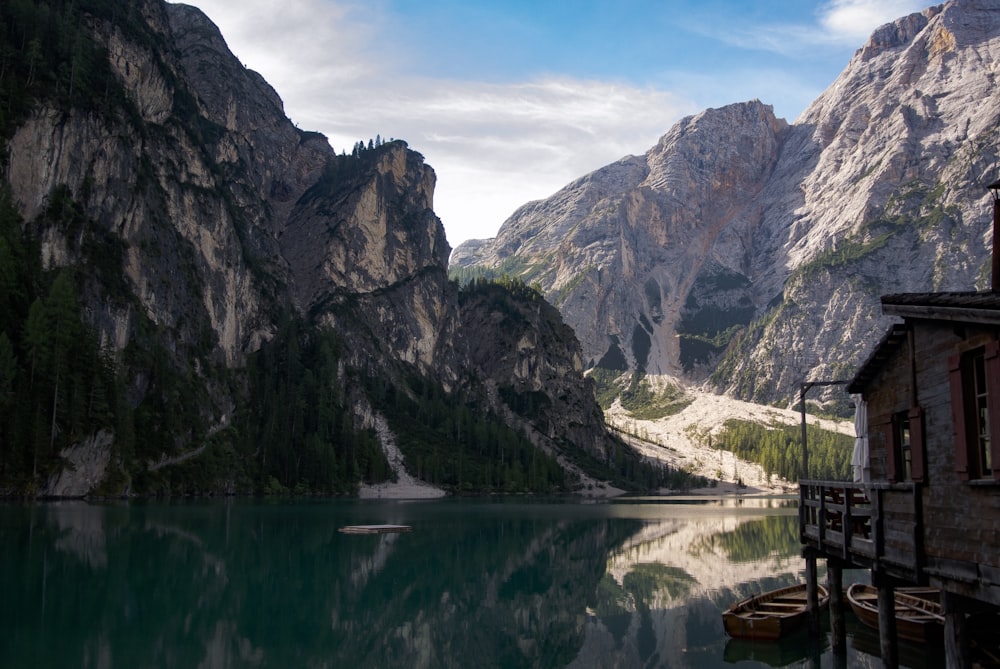 a lake surrounded by mountains with a boat in the water